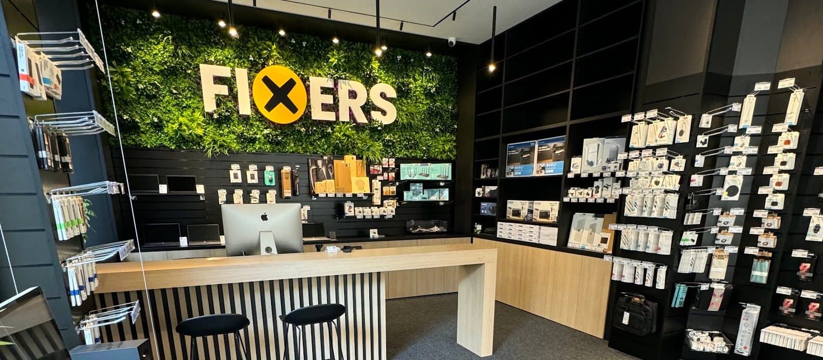 The FIXERS shop in Hradec Králové: green wall with the logo, counter and accessories